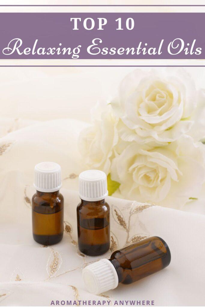 3 essential oil bottles with white roses in the background