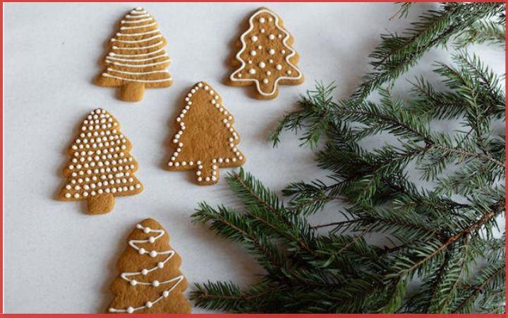 gingerbread cookies shaped like Christmas trees with fir branches at the side