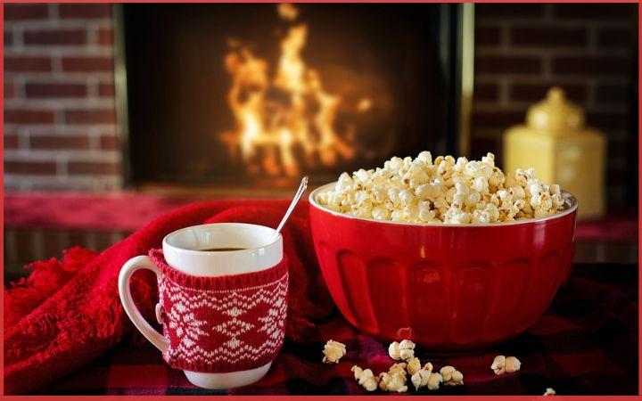 bowl of popcorn alongside a mug of cocoa