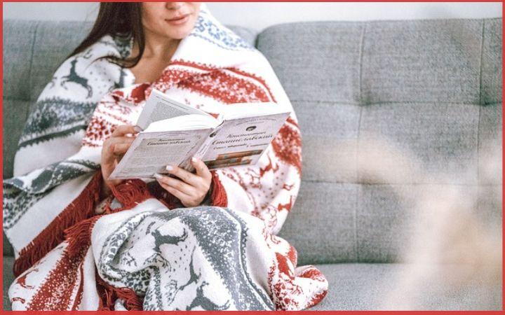 lady sitting wrapped in shawl and reading