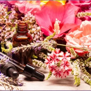 3 spring essential oil bottles against a backdrop of flowers