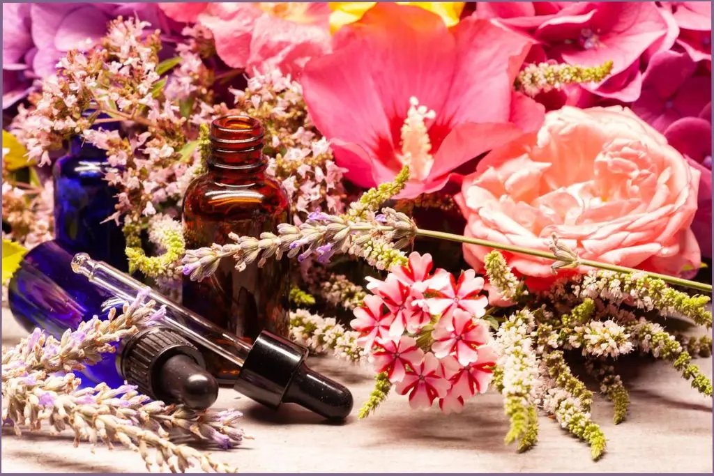 3 spring essential oil bottles against a backdrop of flowers