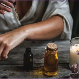 lady putting diluted essential oil on skin with a dropper