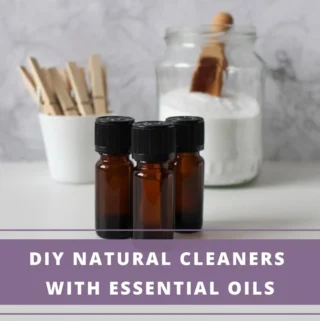3 essential oil bottles + a bottle of baking soda and a mug with clothes pegs in the background
