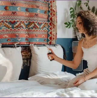 lady spraying relaxing essential oils on pillow