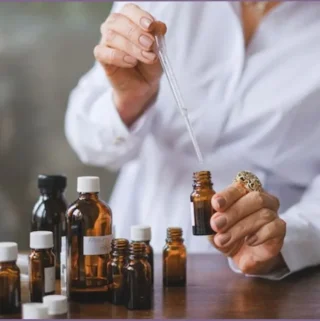 lady using pipette for blending essential oils