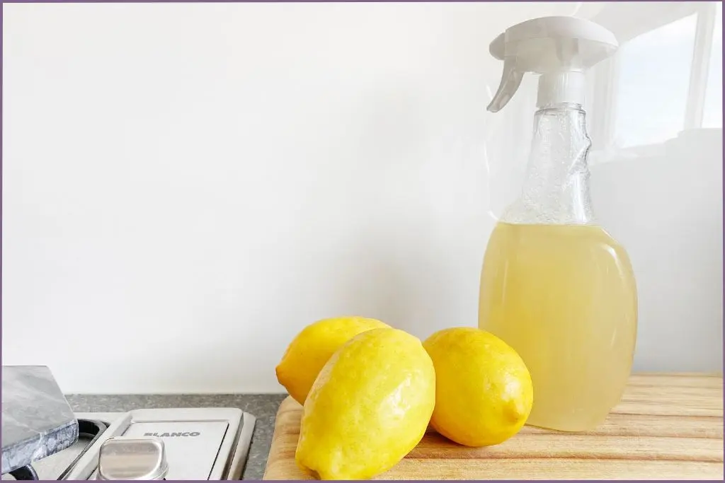 spray bottle with liquid and 3 lemons in foreground