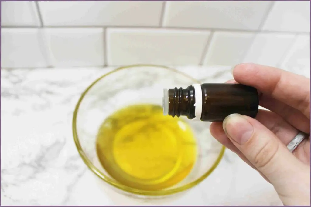 lady adding essential oil to a carrier oil in a bowl