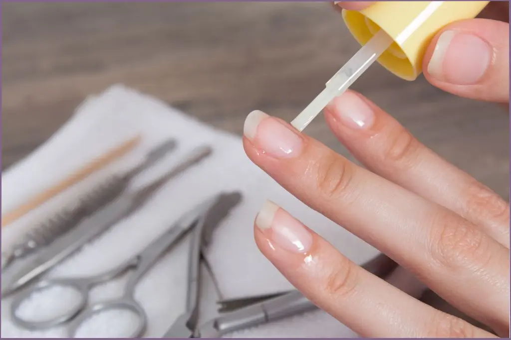 lady applying oil to cuticles