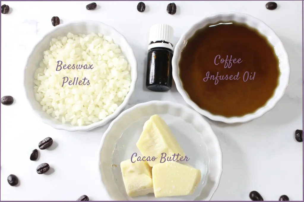 Ingredients for making homemade coffee eye cream - coffee infused oil, beeswax pastiles, cacao butter, and essential oil bottle