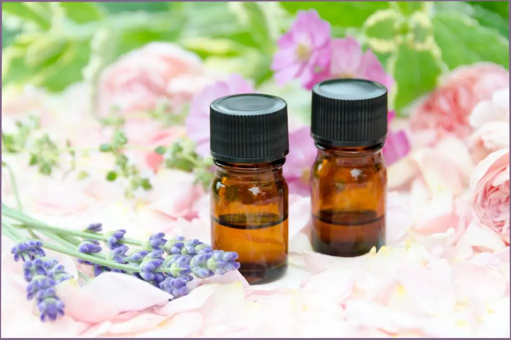 2 essential oil blends with roses and lavender in the background