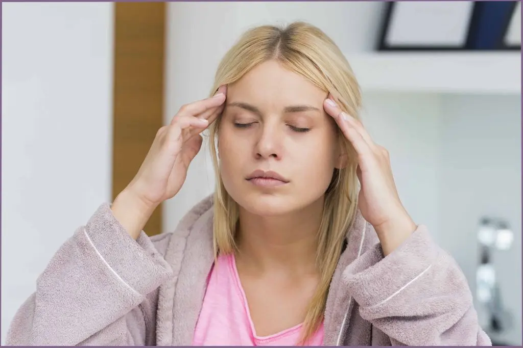 lady with a headache holding her temples