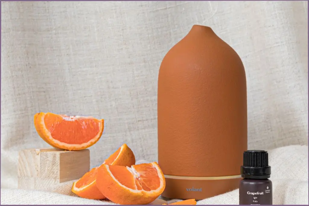 orange diffuser alongside bottle of grapefruit essential oil