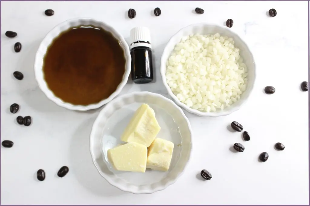 Ingredients for making homemade coffee eye cream - coffee infused oil, beeswax pastiles, cacao butter, and essential oil bottle