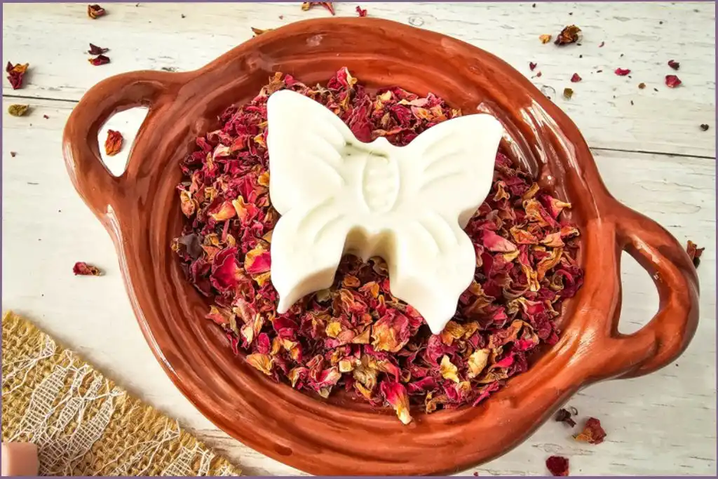 white butterfly soap in a bowl with rose petals