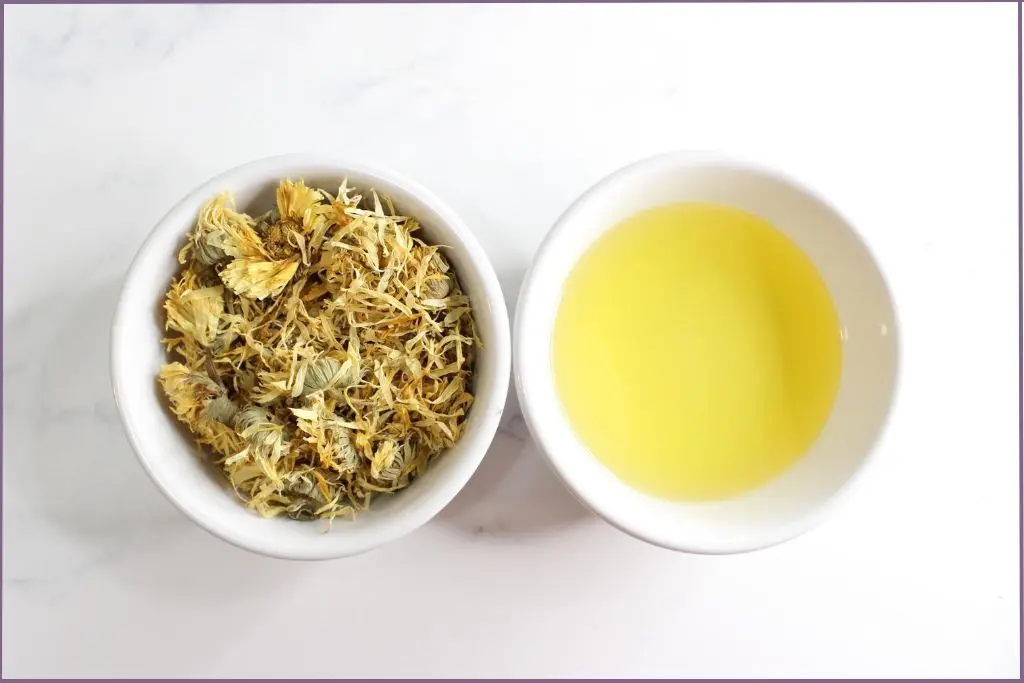 2 bowls with calendula flowers and carrier oil - Benefits of calendula oil for skin