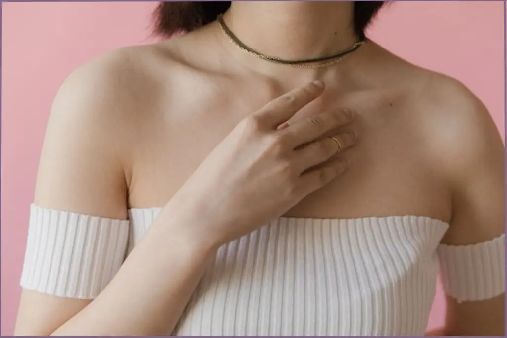 lady applying balm to her upper torso - chest as a pulse point for essential oils