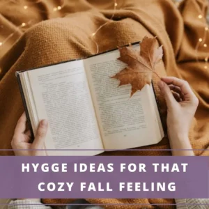 Lady wrapped in a brown blanket reading a book- hygge ideas for fall