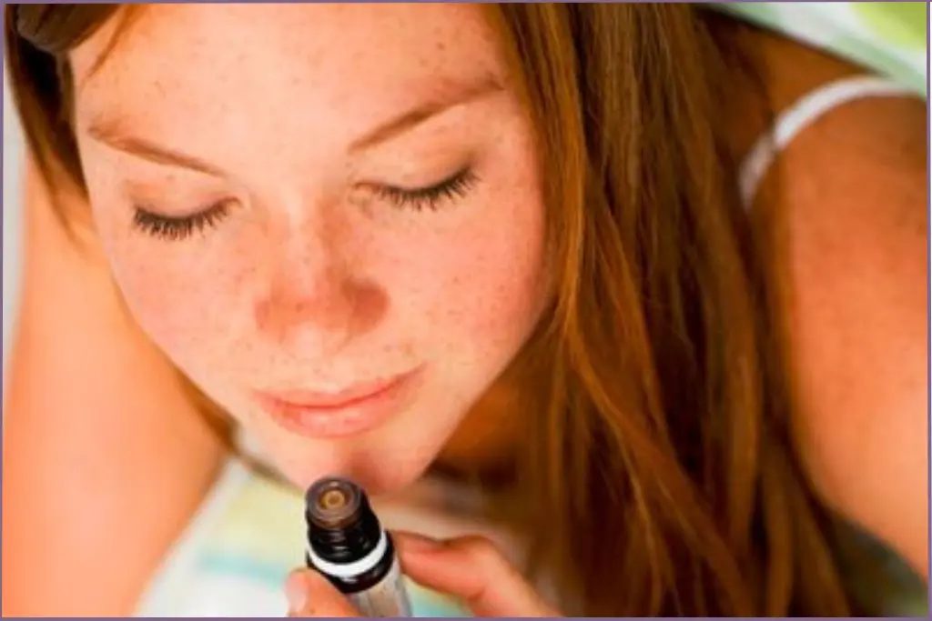 lady inhaling essential oil directly from bottle