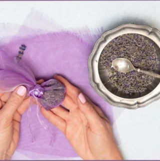 lady holding sachet filled with dried lavender flowers + bowl of lavender flowers at the side