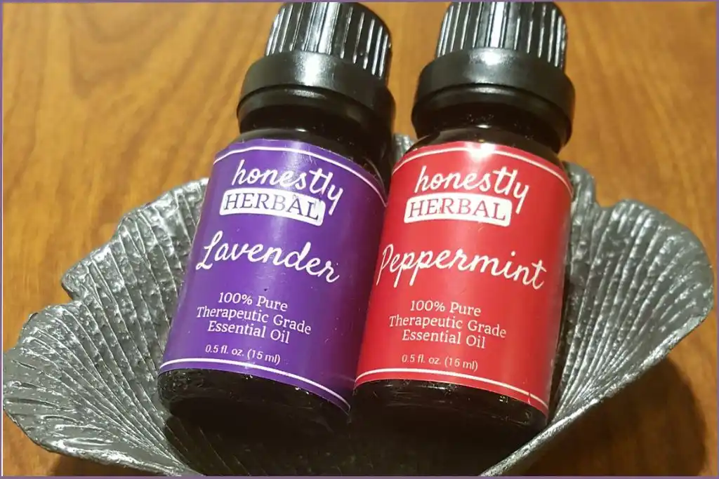 bottles of peppermint and lavender essential oils in a bowl