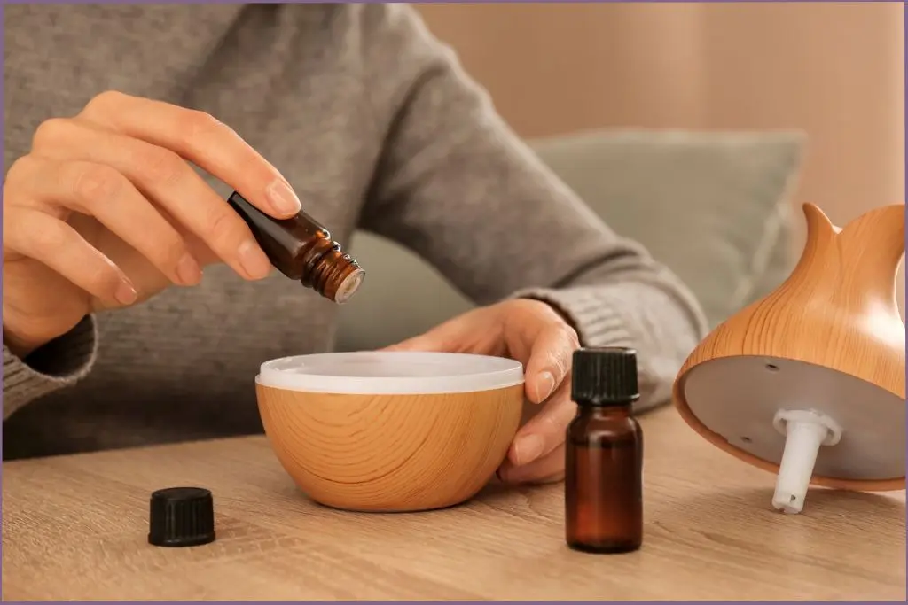 person pouring essental oil in a diffuser