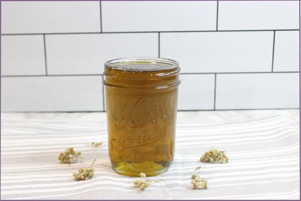 bottle of homemade yarrow infused oil - how to make yarrow oil - benefits for skin