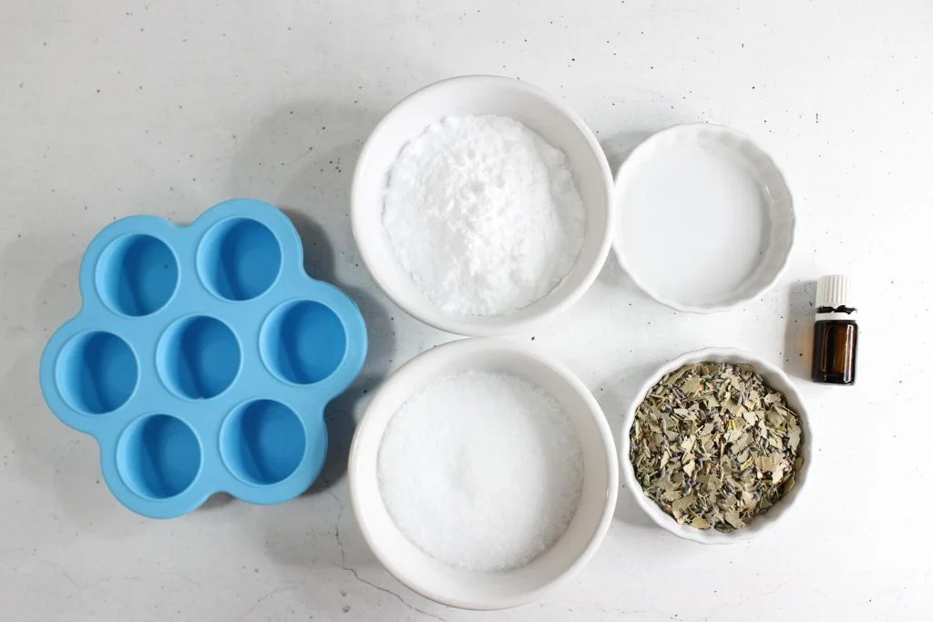 Ingredients for making homemade eucalyptus shower steamers - mold, Epsom salt, baking soda, eucalyptus leaves, water