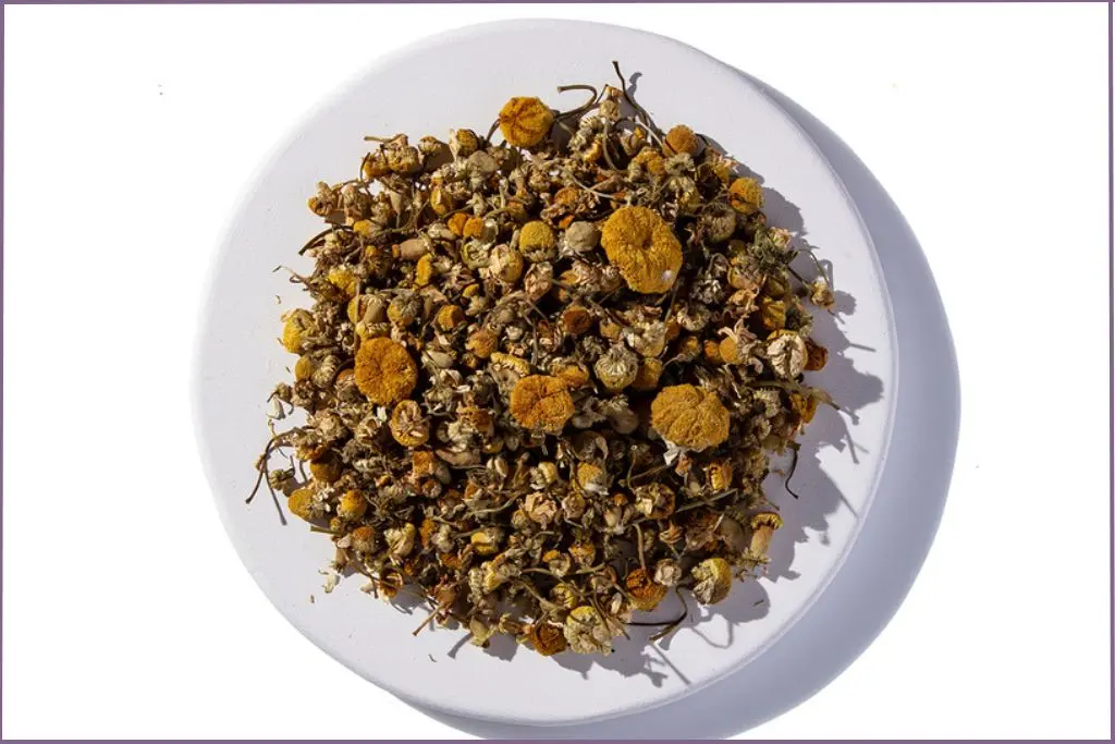 dried chamomile flowers in white bowl