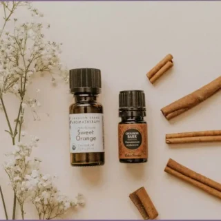 bottles of cinnamon and sweet orange with cinnamon bark at side
