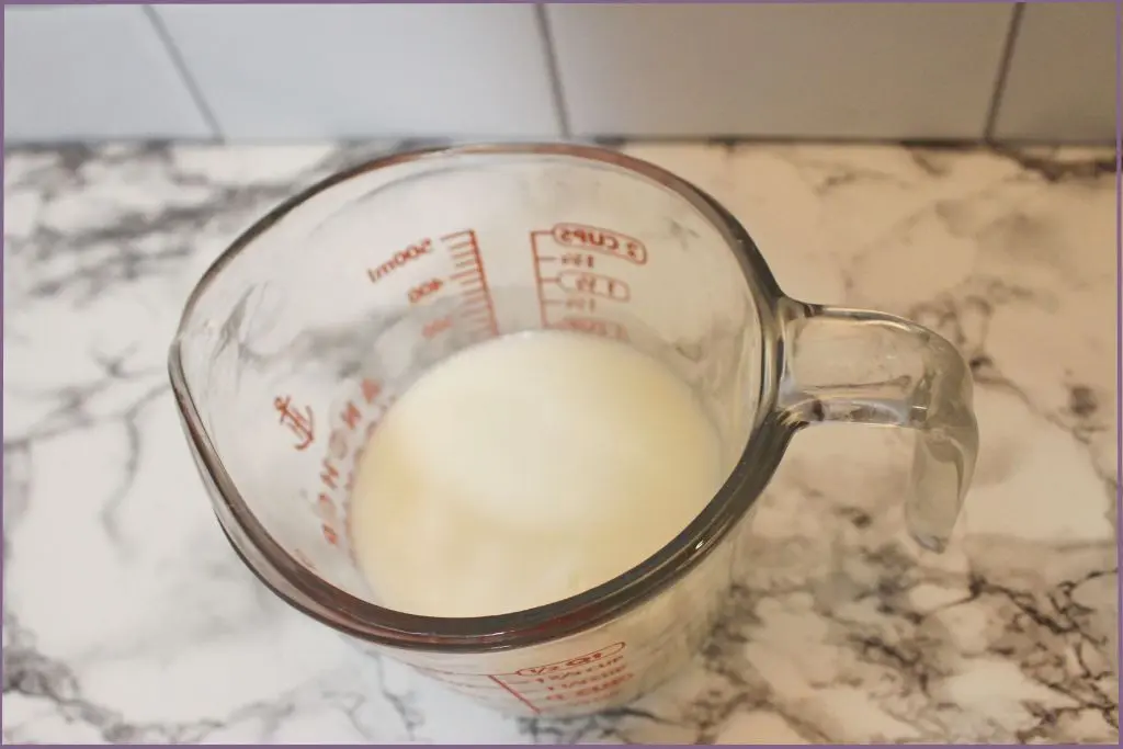 measuring jar with melted ingredients for homemade whipped body butter