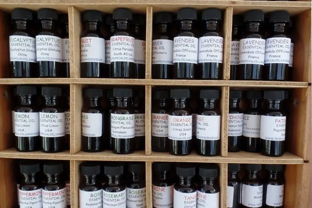 large shelf with essential oil bottles in compartments