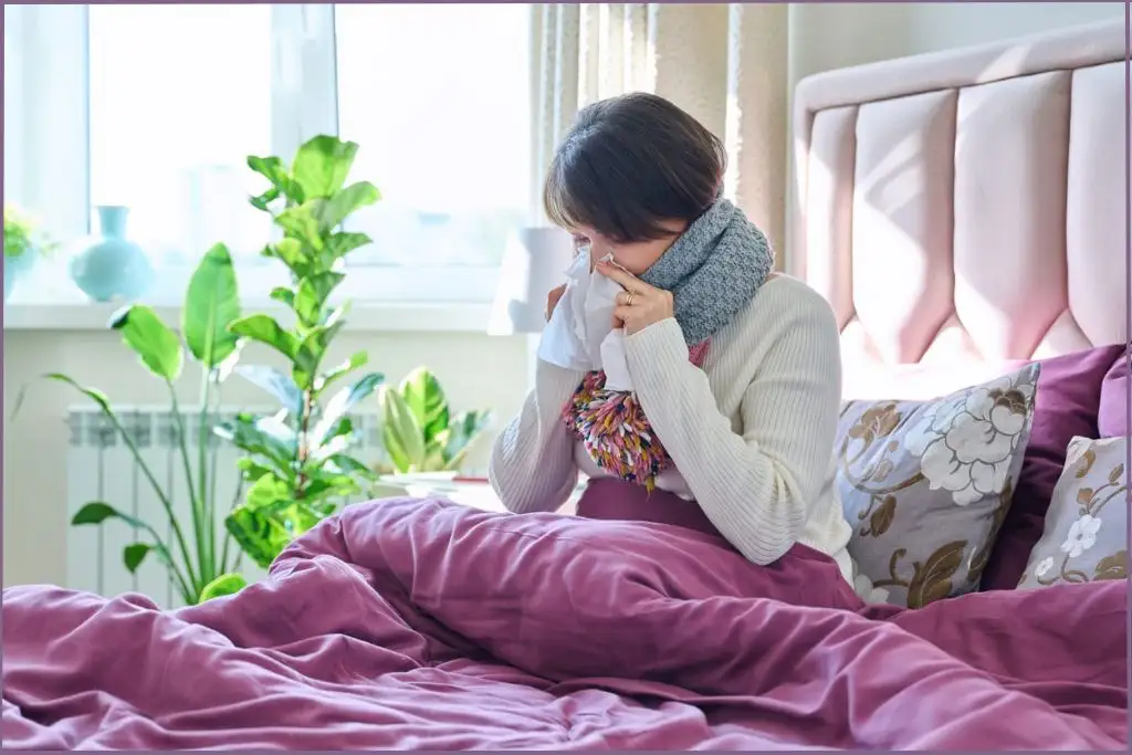 lady with cold holding tissue to her nose