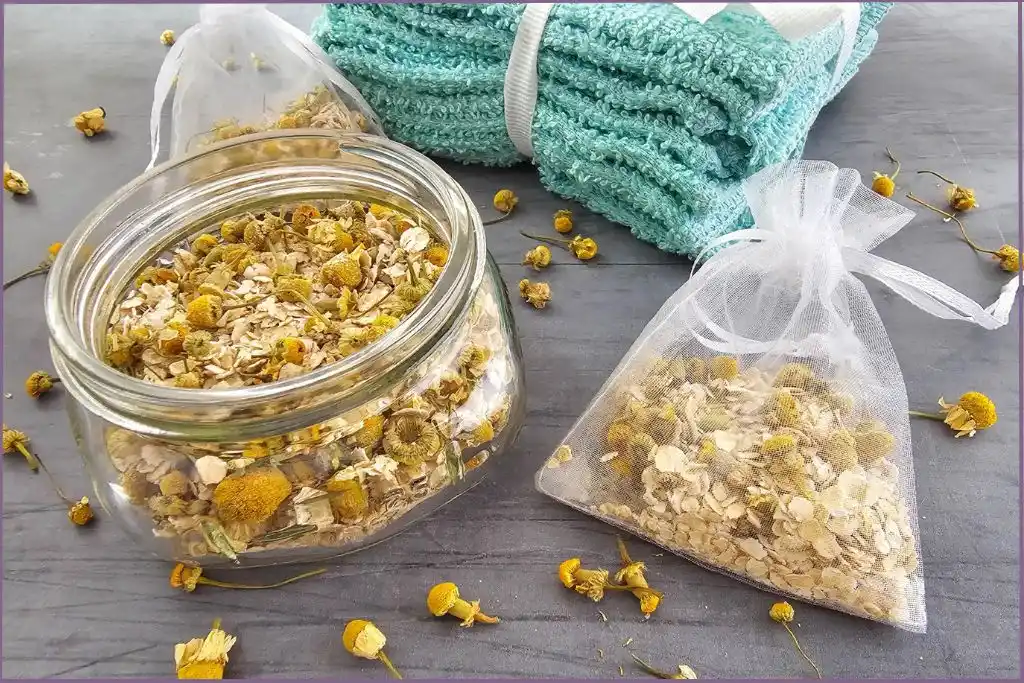 glass bottle and a mesh bag filled with chamomile and oatmeal to make herbal bath tea bags