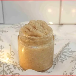 glass jar with homemade Christmas cookie sugar scrub on Christmas tablecloth