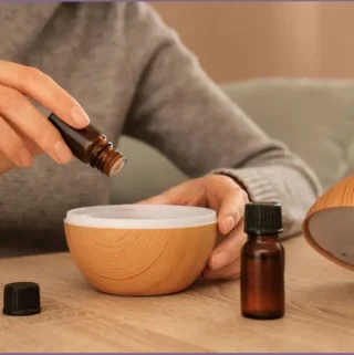 lady adding essential oil drops into a diffuser