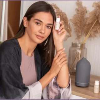 lady holding bottle of warm essential oil