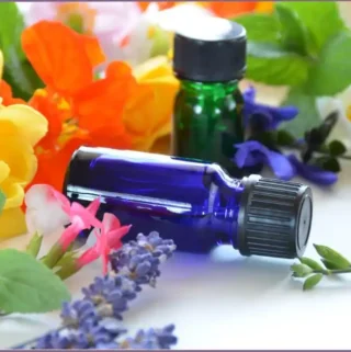 2 essential oil bottles with flowers in the background