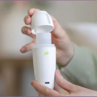 lady holding a mini portable essential oil diffuser