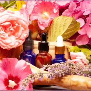 3 essential oil bottles amidst colorful flowers - tropical diffuser blends