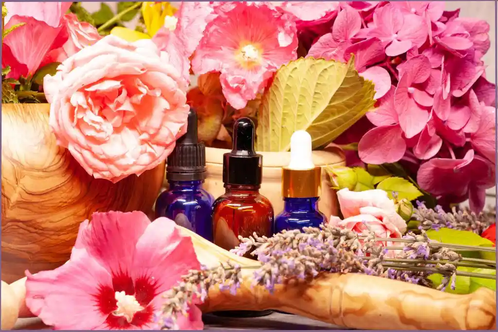 3 essential oil bottles amidst colorful flowers - tropical diffuser blends
