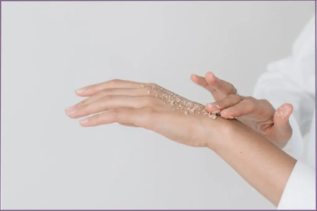 lady applying scrub on her hand - benefits of using essential oils in skin care