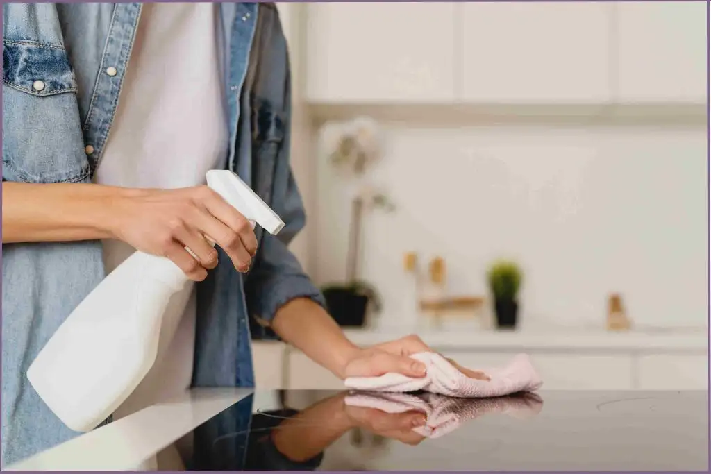 lady wearing denim jacket using homemade cleaning spray with essential oils