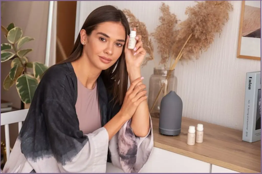 lady wearing relaxed clothes sitting next to an aromatherapy diffuser