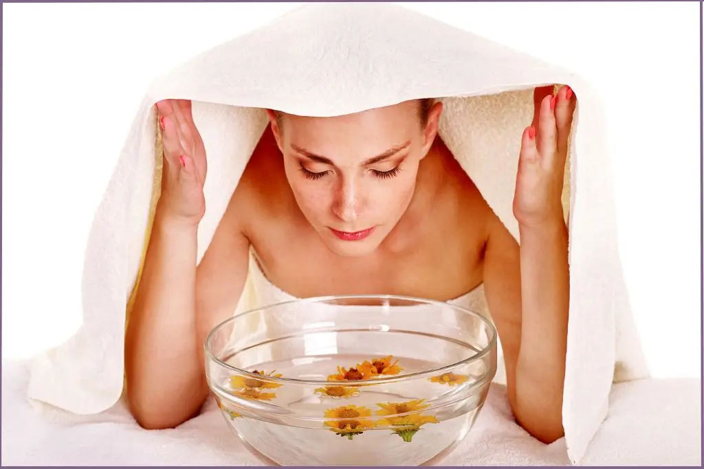 lady steaming face over a bowl of hot water with essential oils