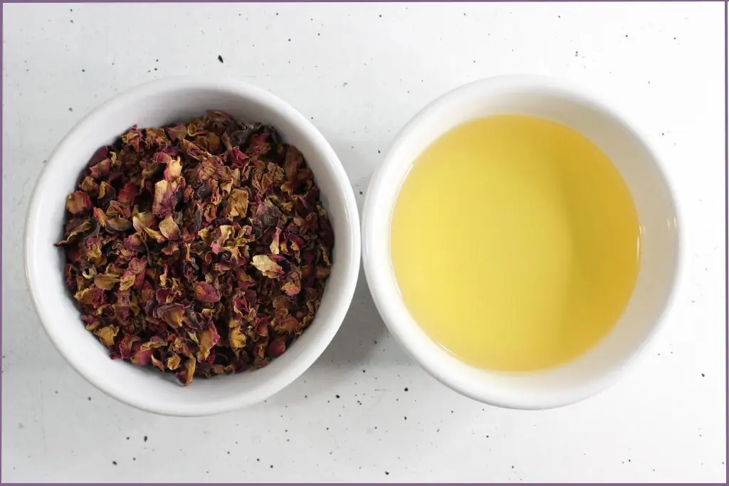 two white bowls - one with dried petals and one with carrier oil to make rose oil with dried petals