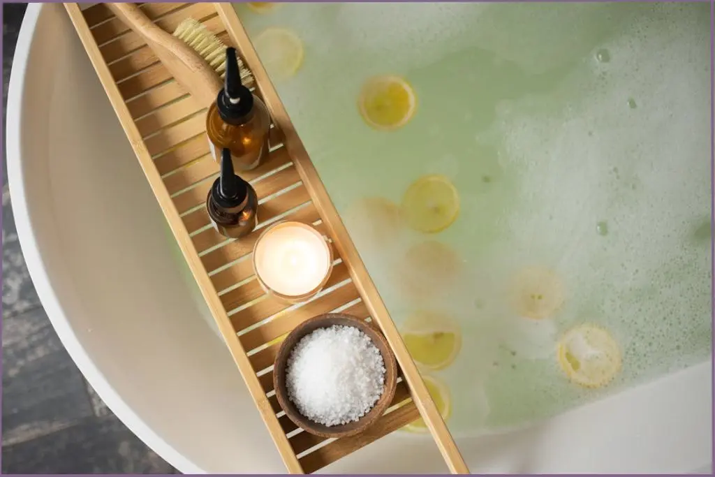 bath tray with cooling bath blends and bath salts lying across a bath tub