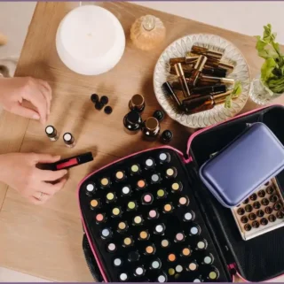 Aromatherapy diffuser, essential oil bottles, and roller bottles on a wooden table