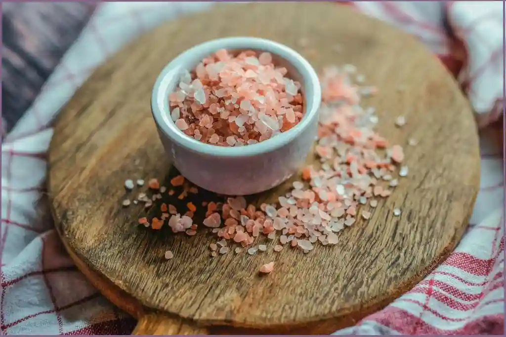 white ceramic bowl with Himalayan salt on a round wooden trivet