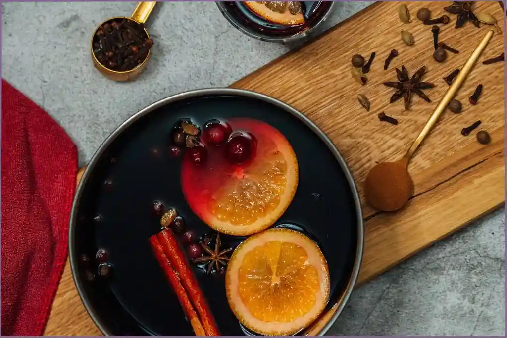 orange slices, cinnamon sticks, cranberries and water in a pot- Cozy winter warmer stovetop potpourri recipe